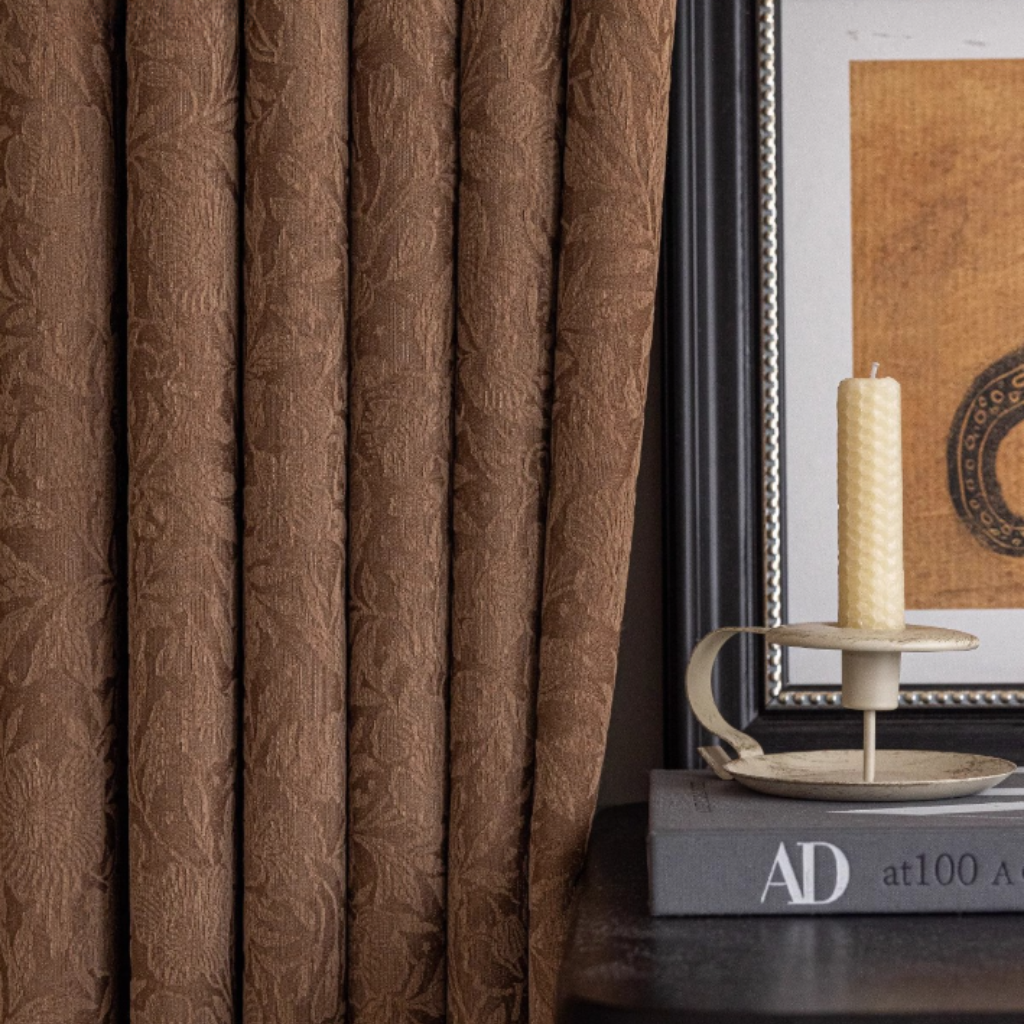 Brown textured blackout curtain with a candle and books in the background