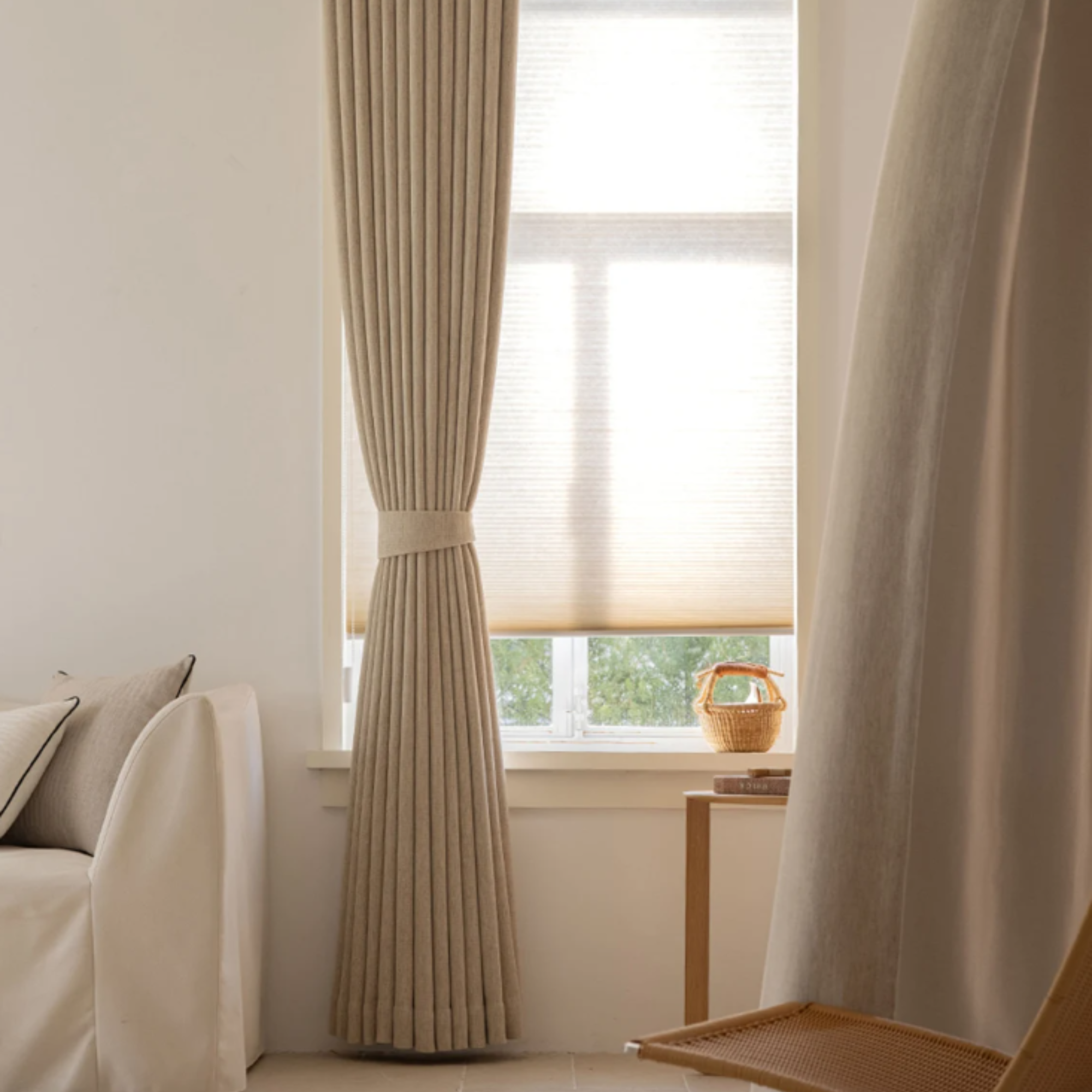 Beige blackout curtains in a room with a couch and window.