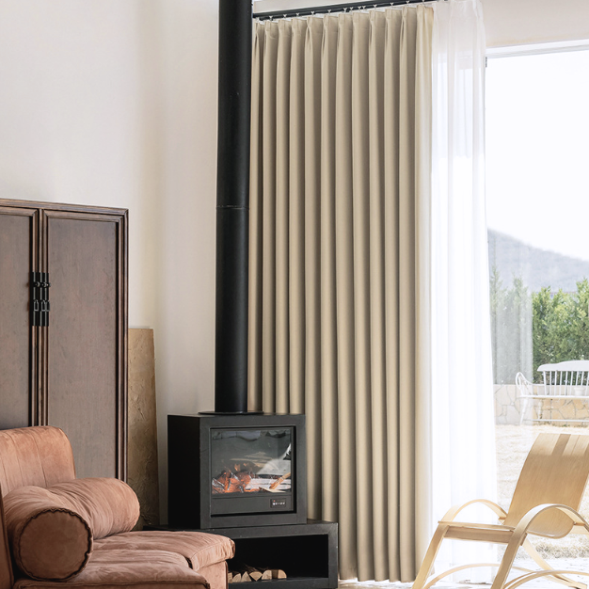 Living room with a fireplace, brown sofa, and large window with beige blackout curtains.