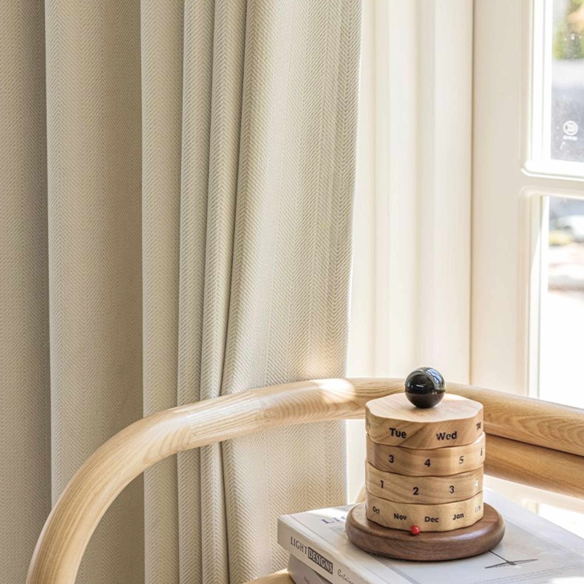 White herringbone room darkening curtains behind a wooden decoration