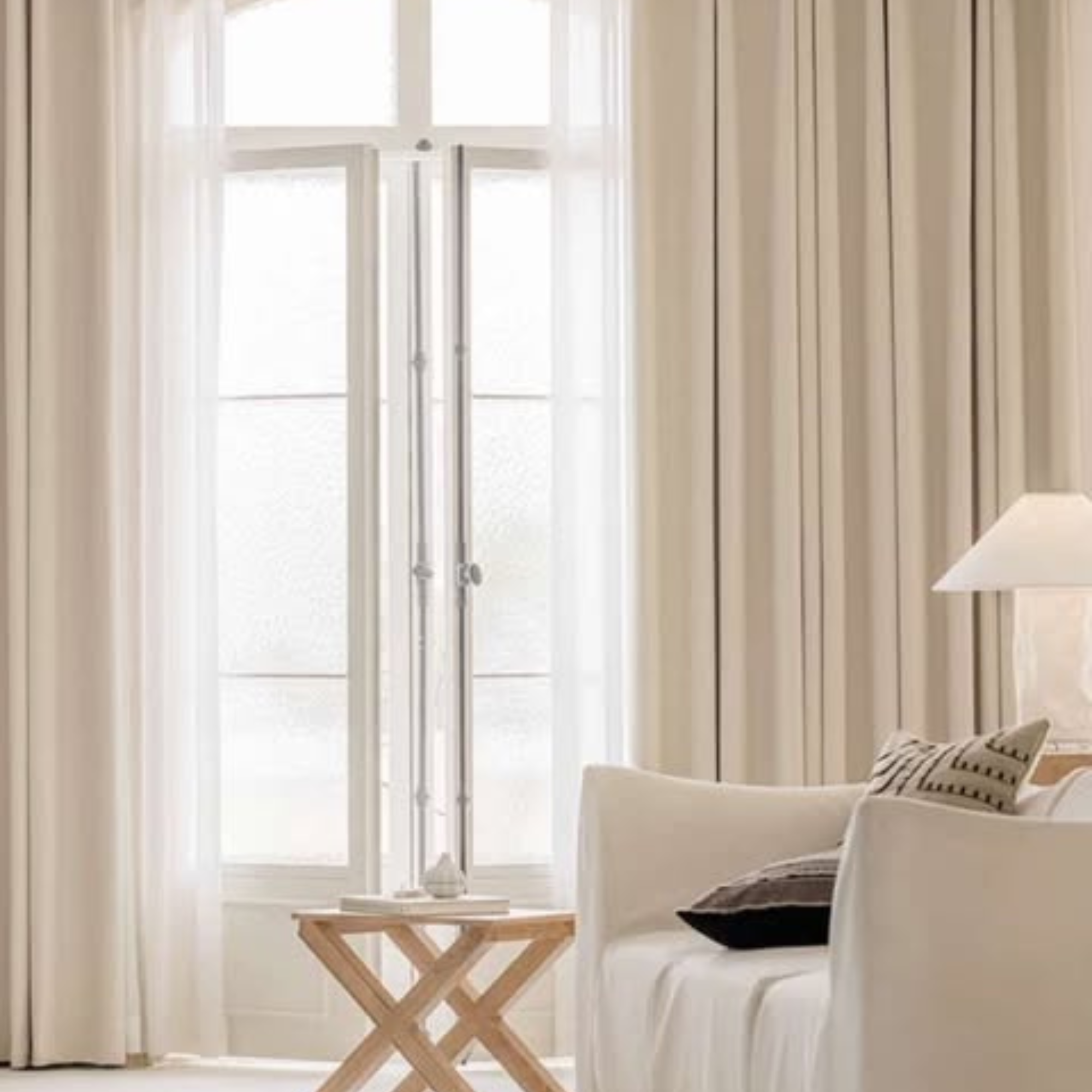 Living room with white herringbone room darkening curtains, a lamp, and a couch.