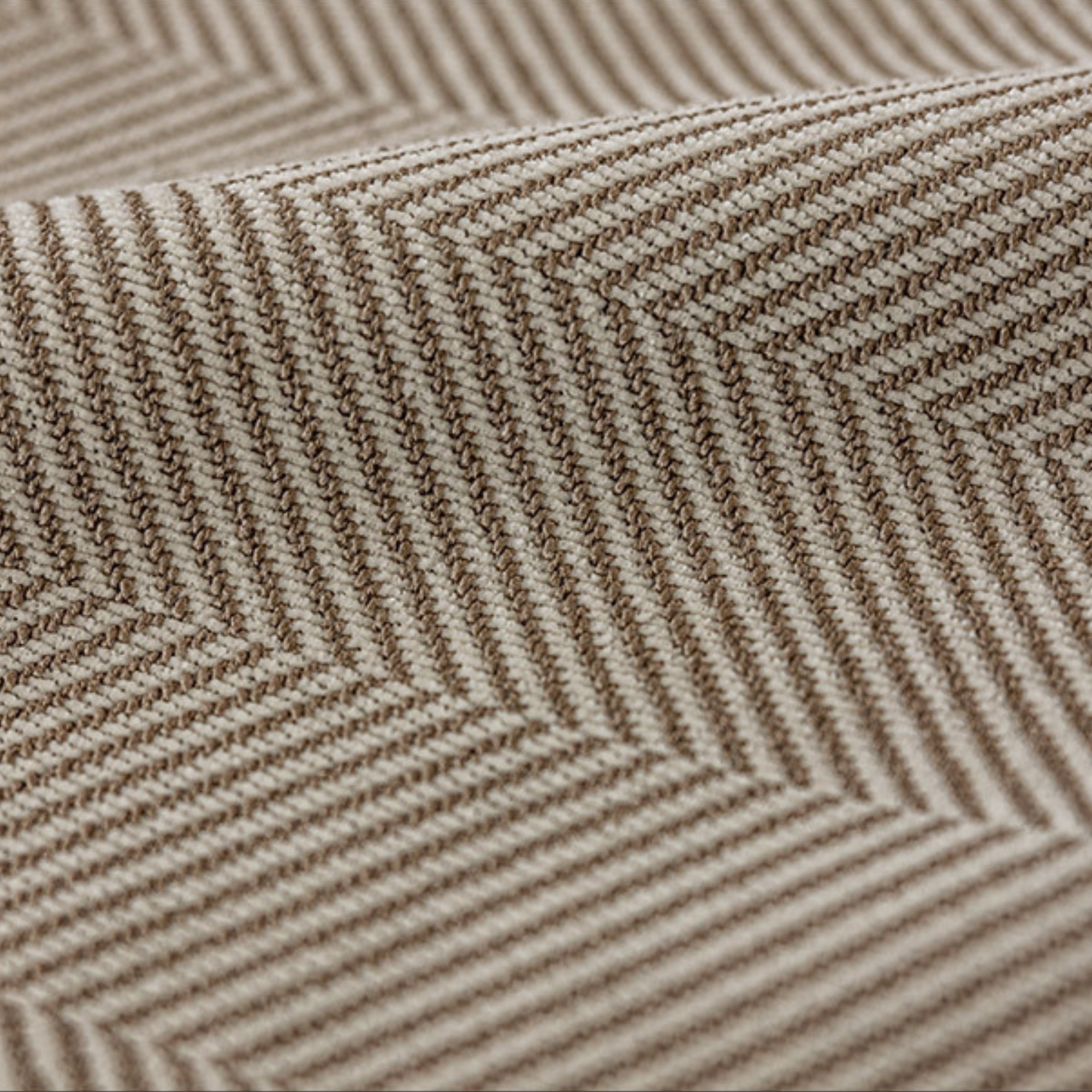 Close-up of a textured fabric with a herringbone pattern in brown and beige.