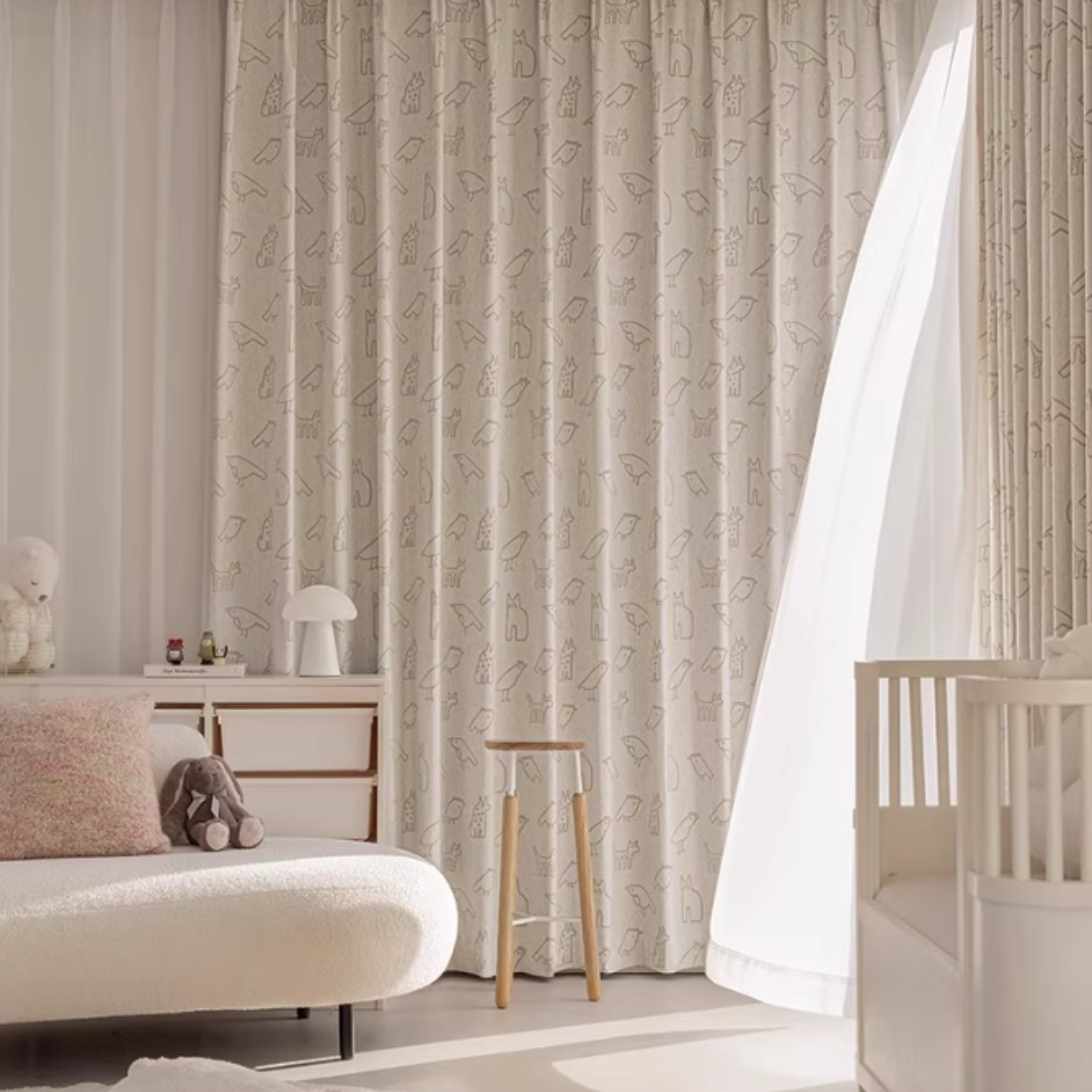 Nursery room with animal doodle patterned curtains and a crib.