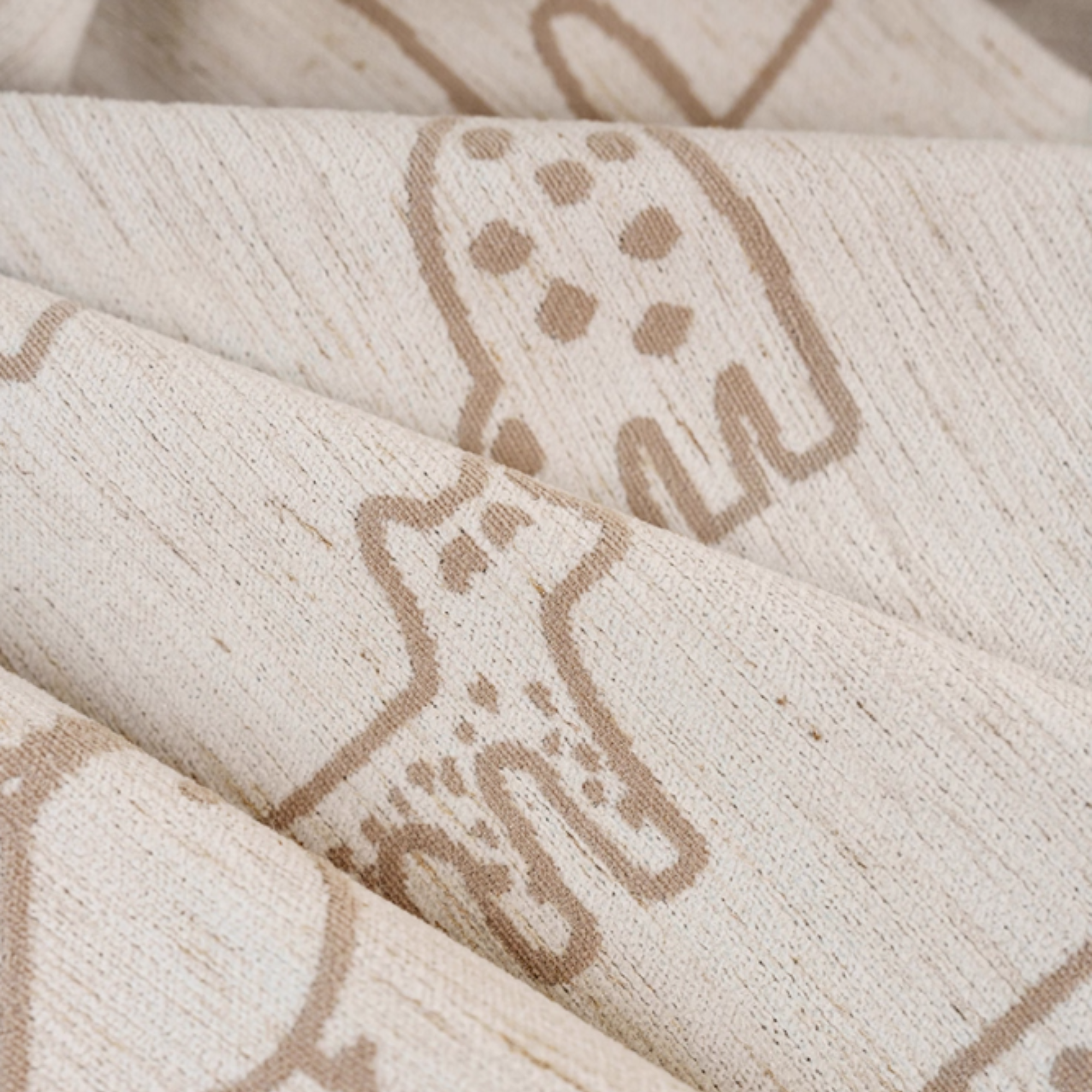 Close-up of textured curtains with animal pattern in brown on a beige fabric