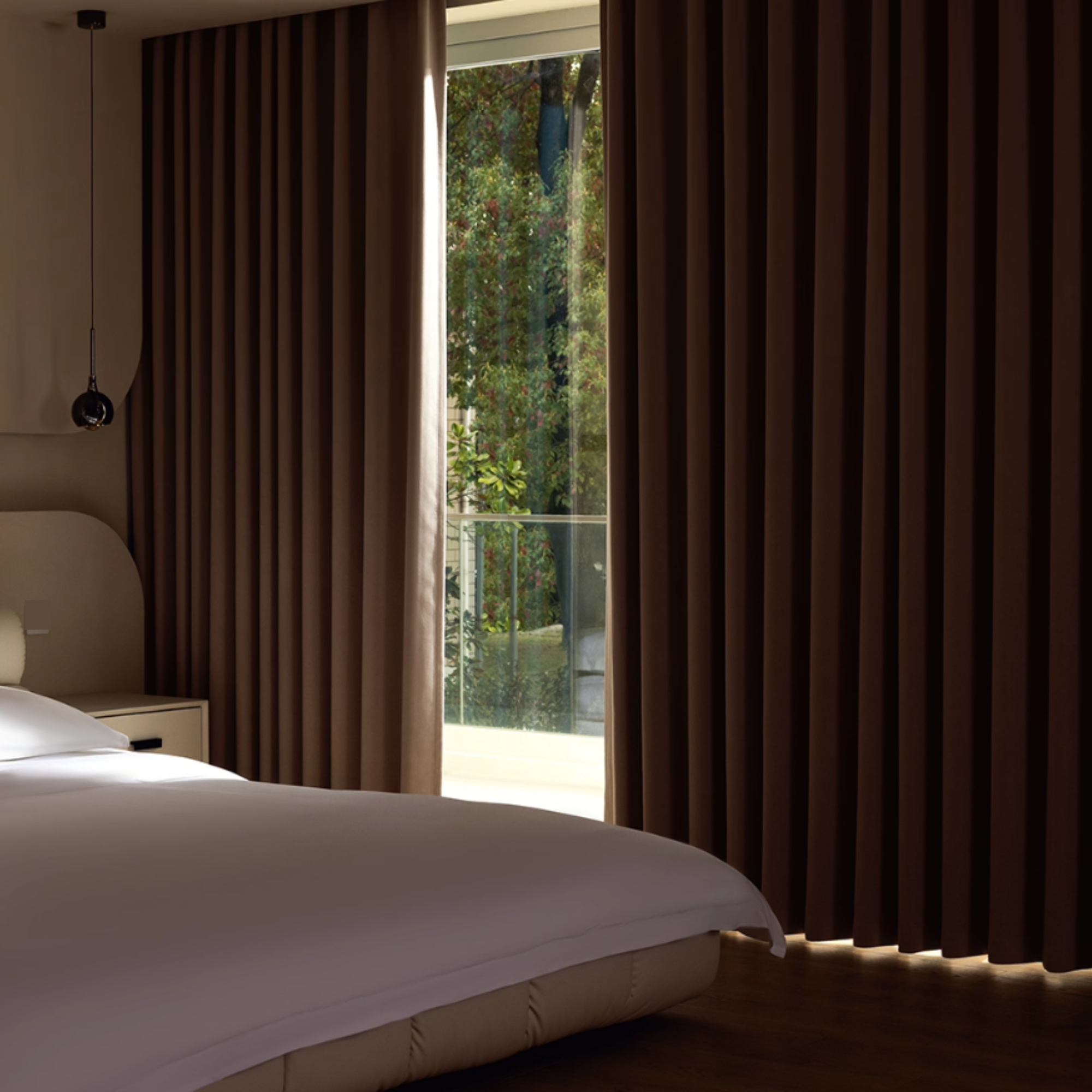 Bedroom with cream colored blackout curtains,showing the light blocking effect during the day