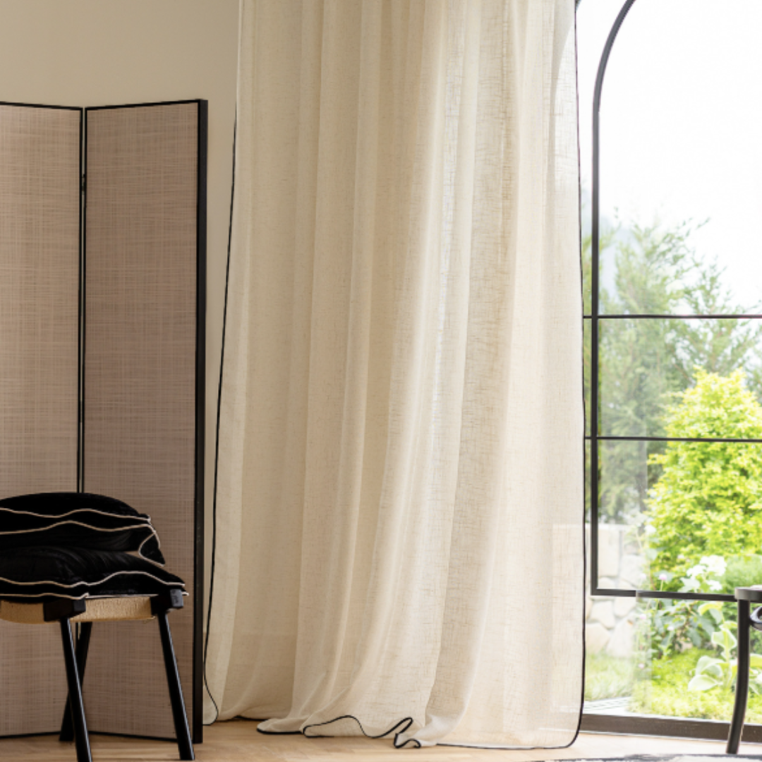 Sheer linen curtain in natural flax color in front of a patio door