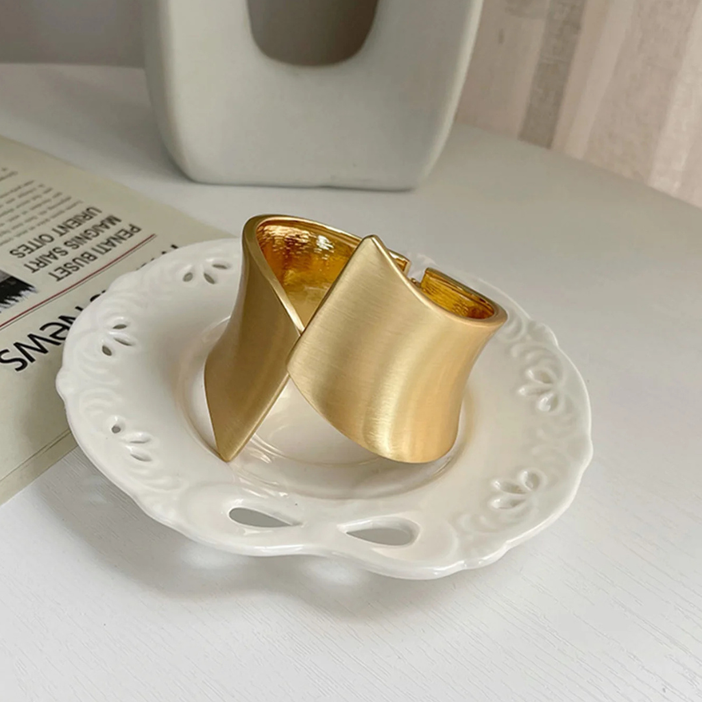 Gold curtain tieback on a white dish with a blurred background