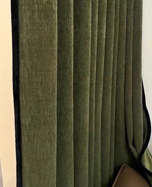 Green pleated curtain against a white wall