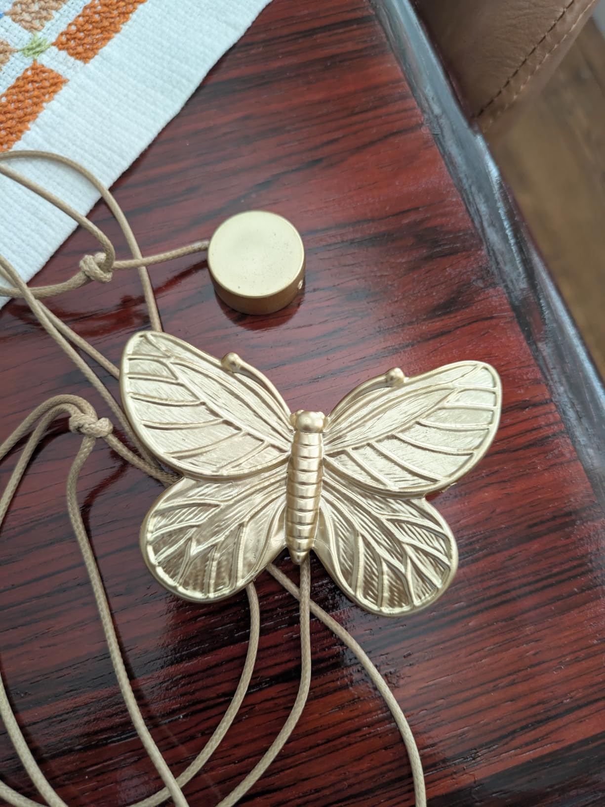 Gold butterfly curtain tieback on a wooden surface