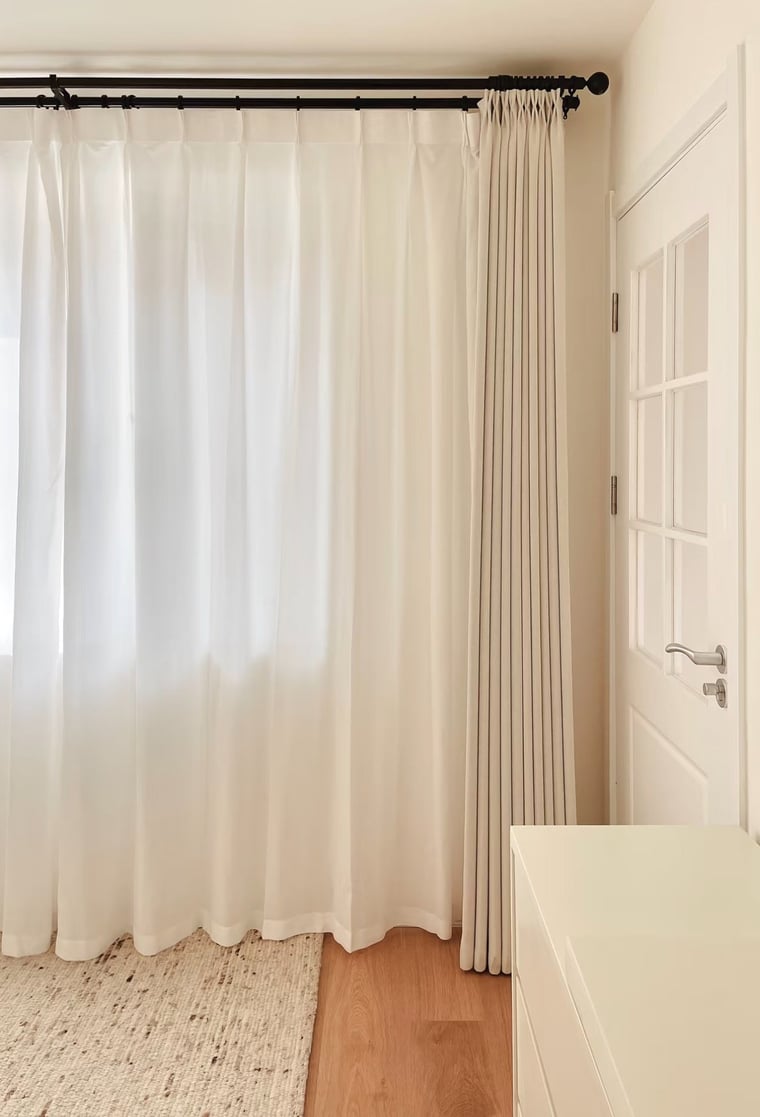 White privacy curtains with a gradient effect in a room with wooden flooring and a white door.