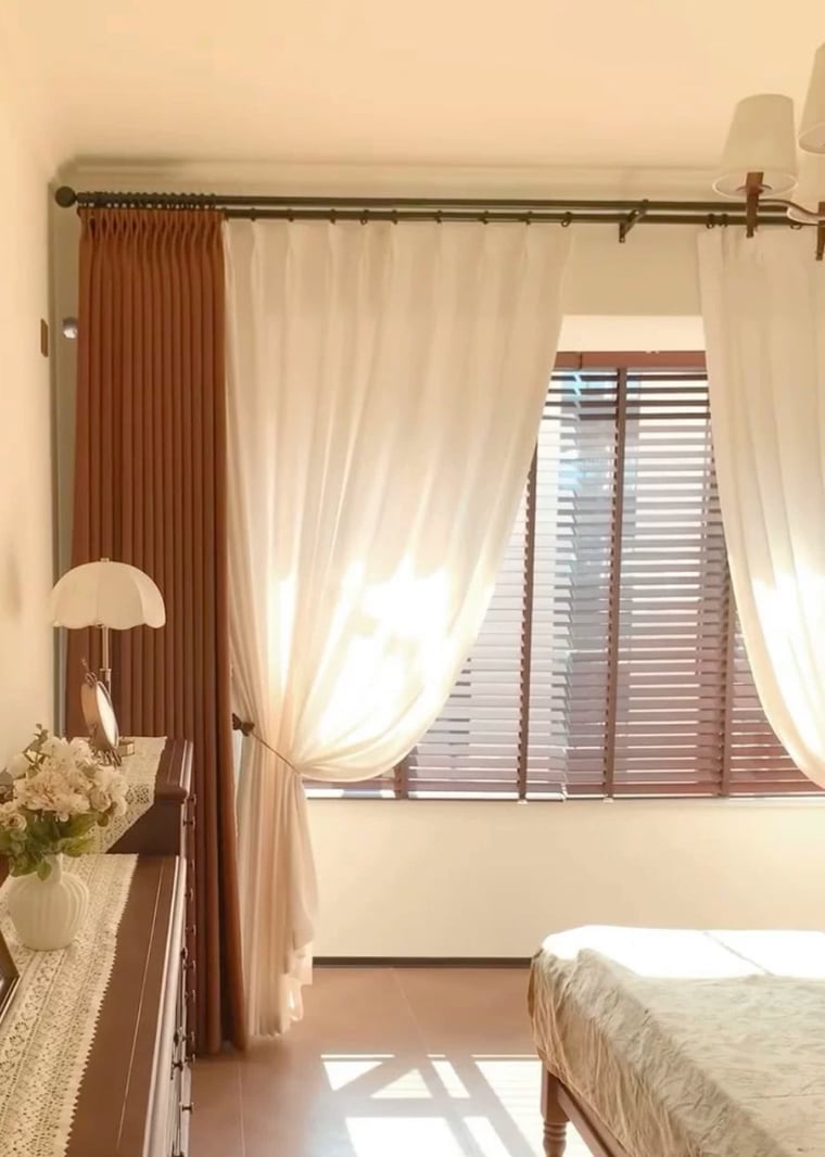 Room with white privacy curtains, blinds, and a lamp in a bedroom setting