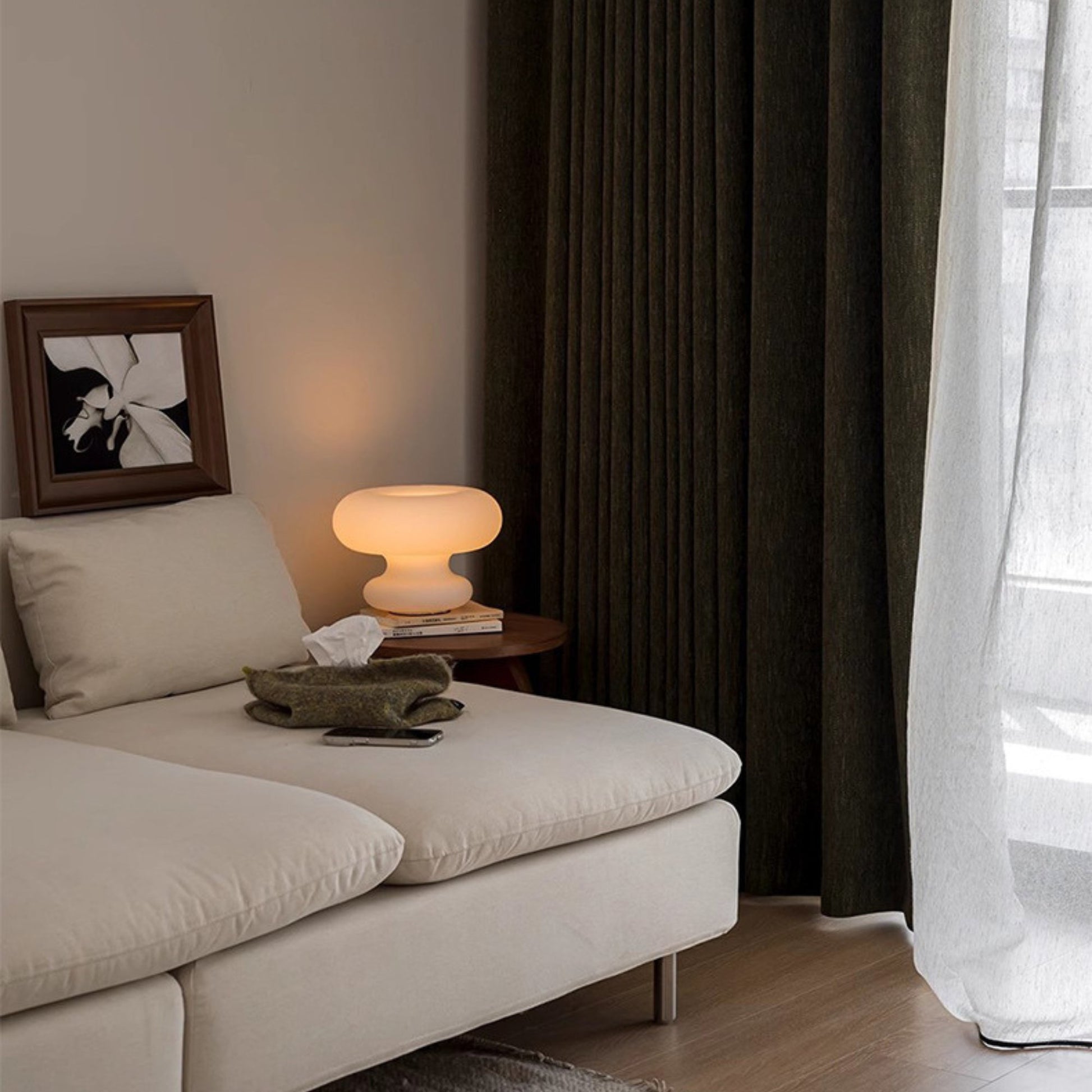 Olive green room darkening curtains hanging in a living room window, providing privacy and style.