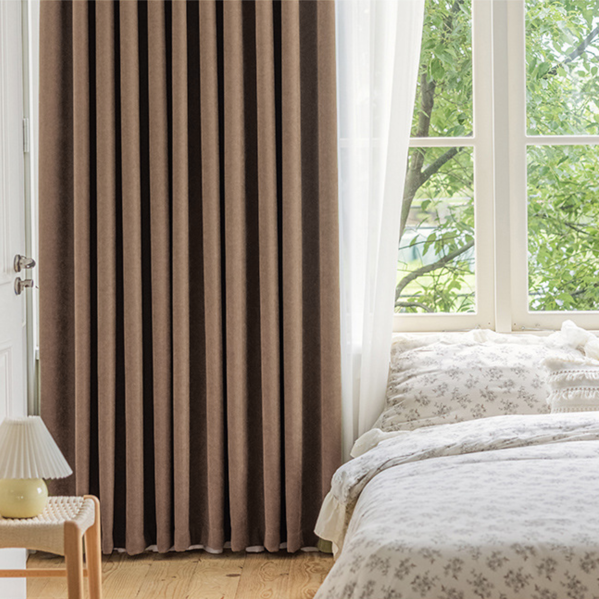 Brown herringbone curtain in a bedroom with a window and bed in the background