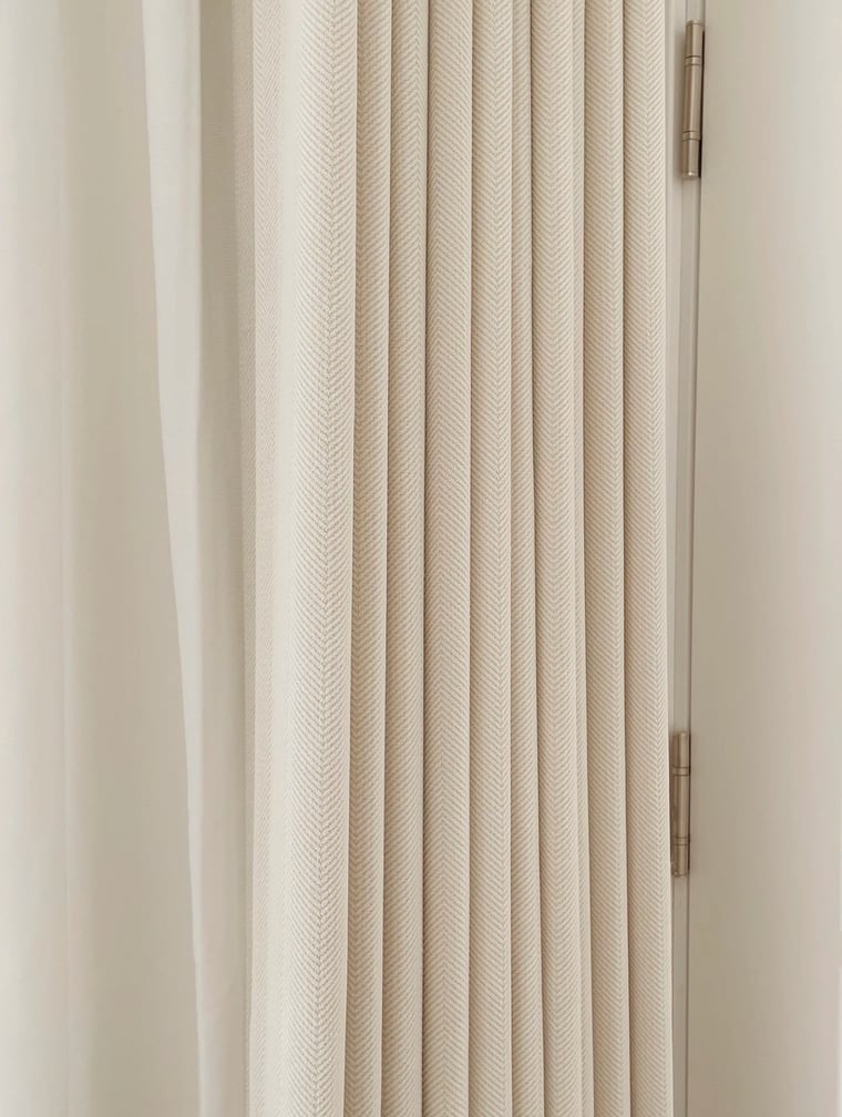 Close-up of a herringbone textured cream curtain with a slight sheen.