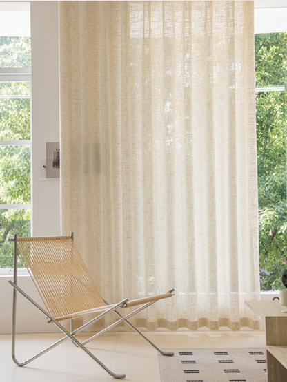 Floor-length linen sheer curtains in living room, creating an elegant drape.