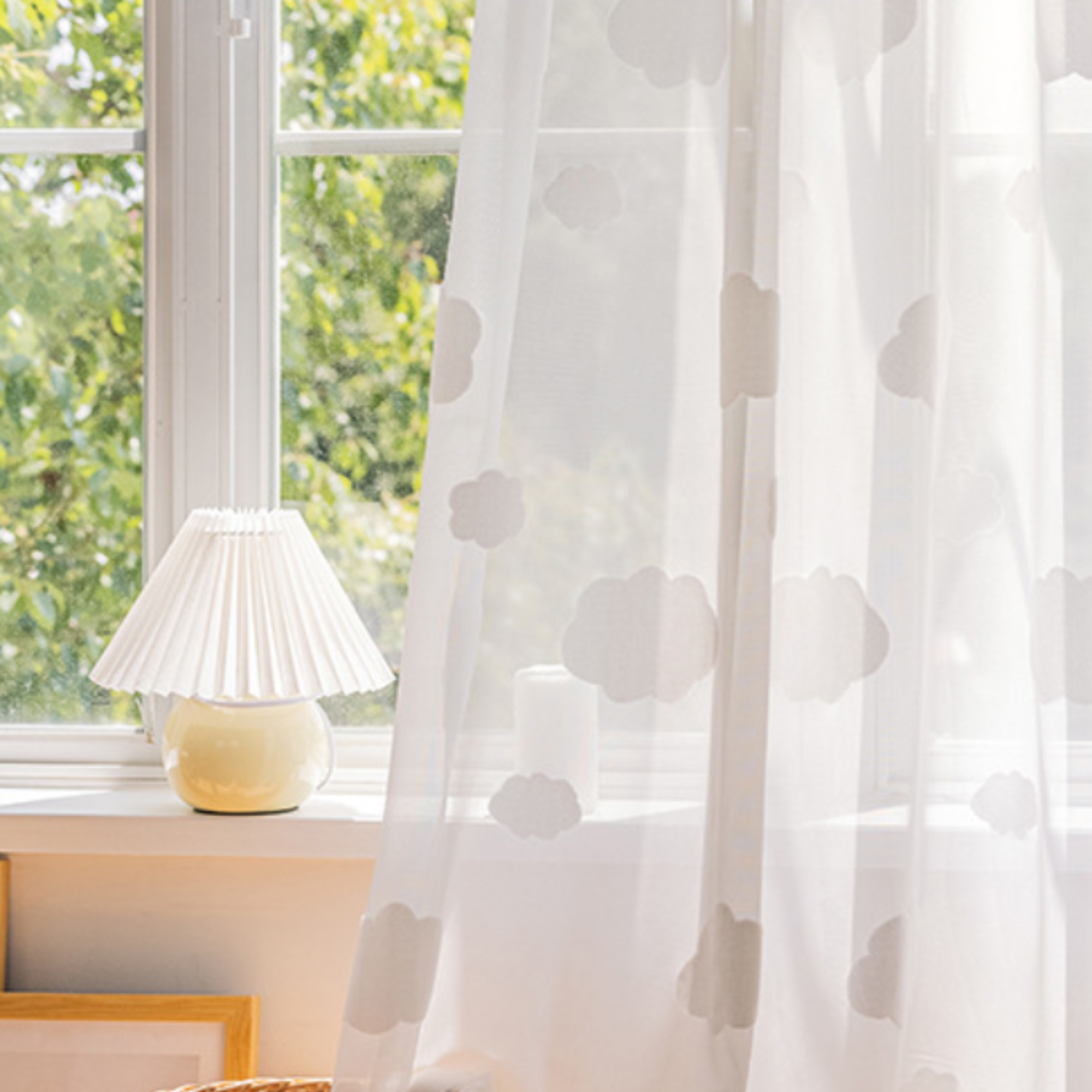 Sheer white curtain with textured cloud pattern in a room with a window and lamp.