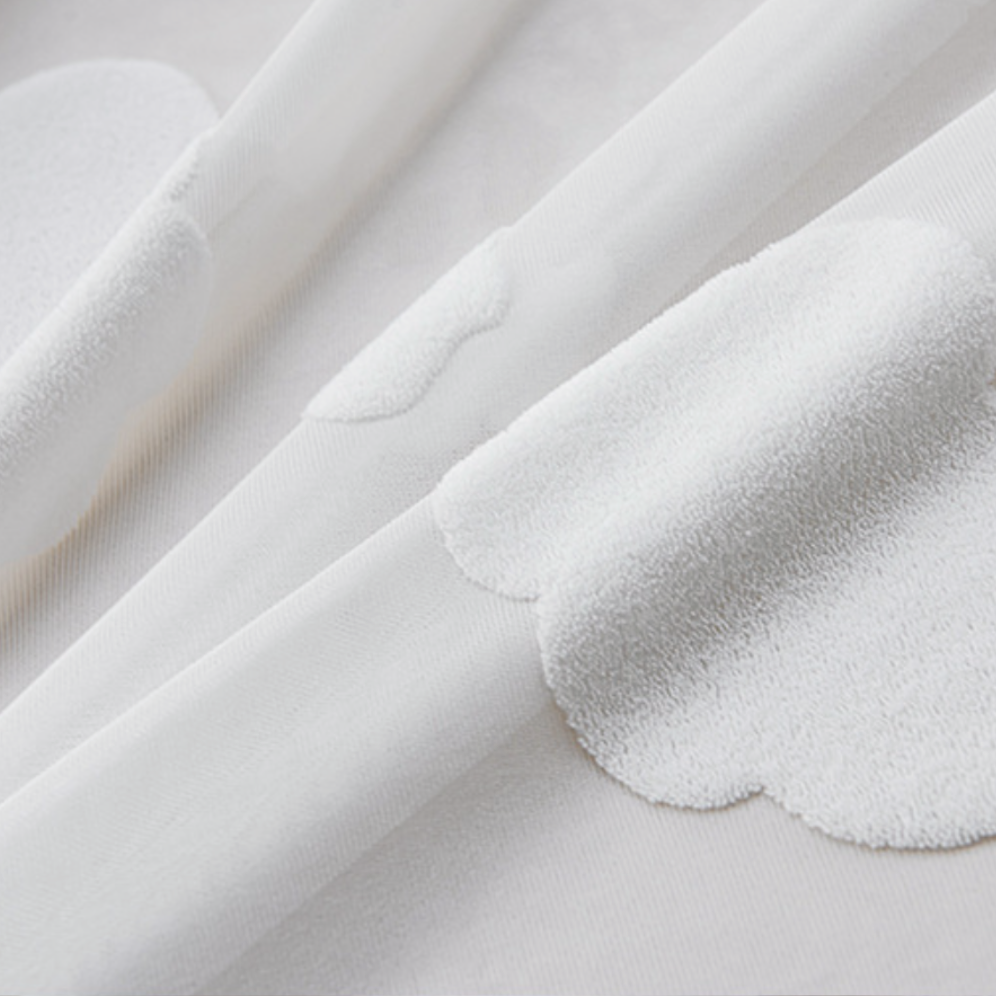 Close-up of white fabric with 3D cloud pattern in a terry texture.