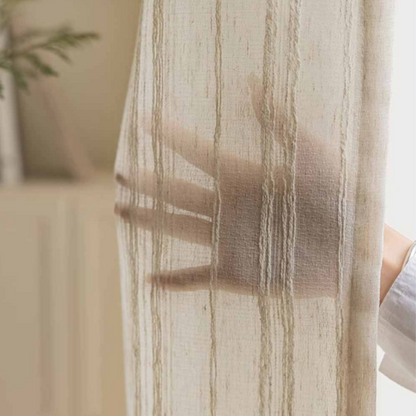 Sheer striped linen curtain with a blurred hand behind it showing how much privacy it can provide