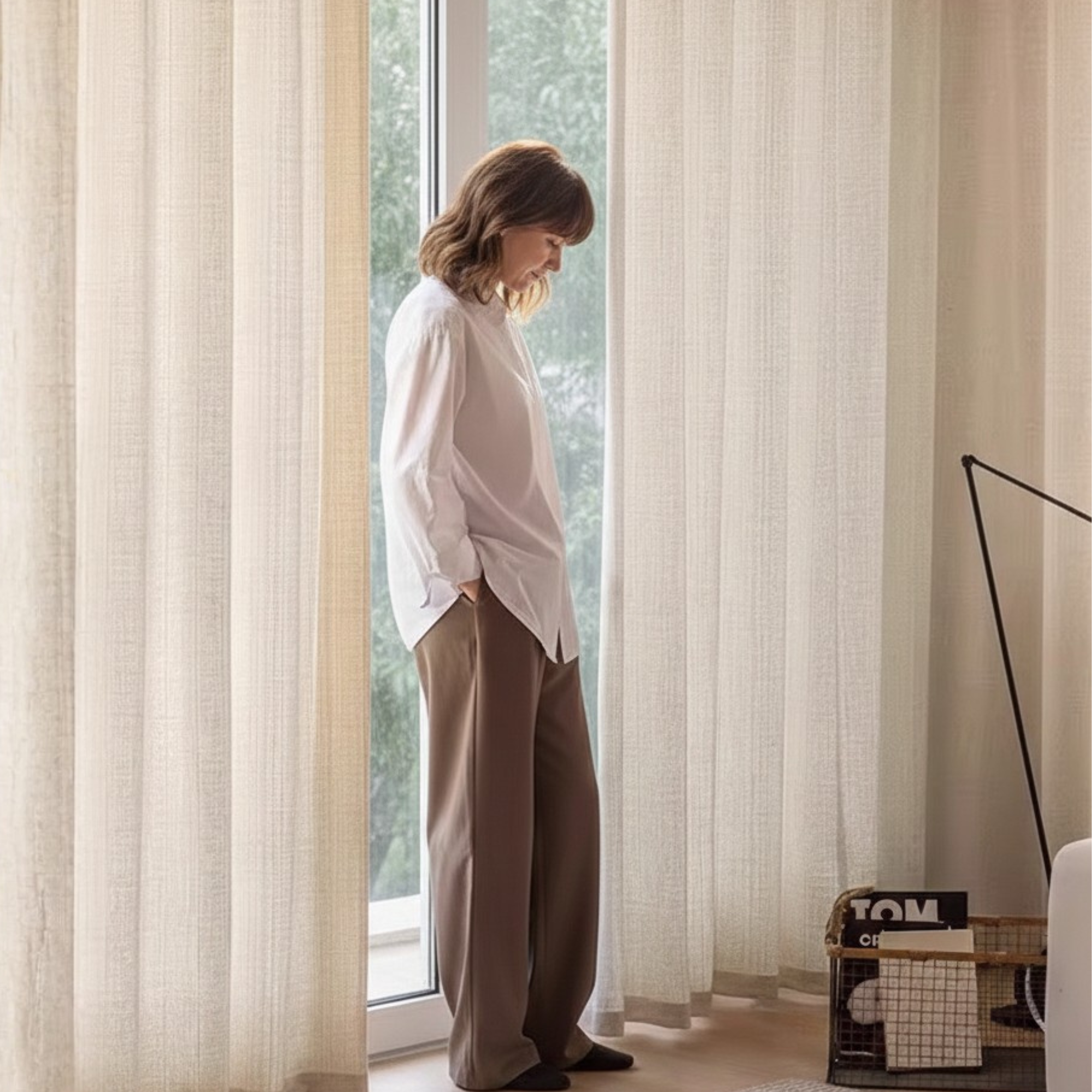 Person standing in a room with white linen curtains for sliding glass door.