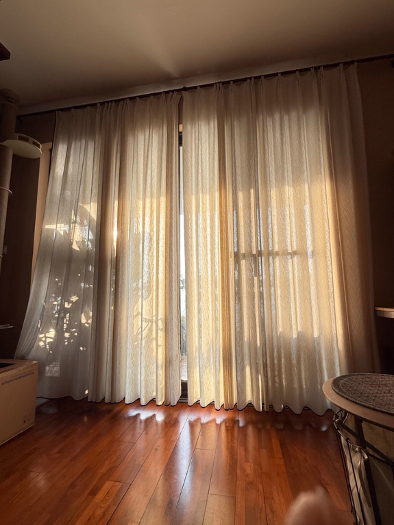 Cream linen curtains for sliding glass doors in a living room with wooden flooring