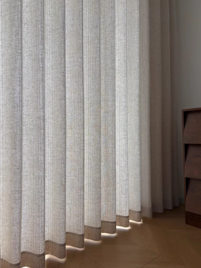 Beige linen curtains with a subtle weave pattern in a room setting